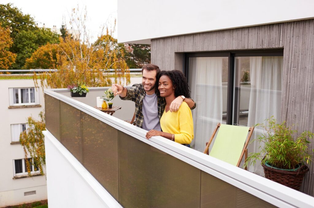 Couple heureux sur un balcon d'appartement